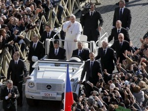 Pope Francis waves to the crowd as he rides through St. Peter's Square