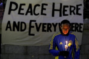 Runner holds candle and flower at vigil