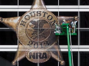 Workers put up the NRA logo in Houston's George Brown Convention Center